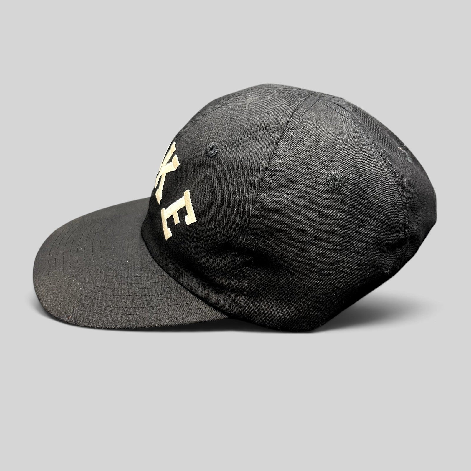 Raree Finds vintage black Nike strapback hat with arched embroidered logo and green undervisor from the 90s