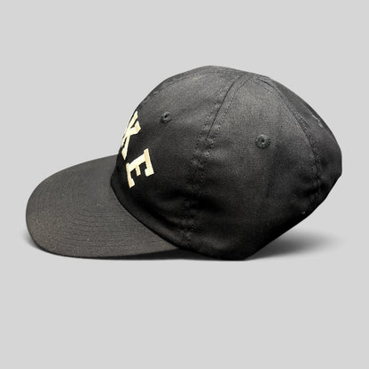 Raree Finds vintage black Nike strapback hat with arched embroidered logo and green undervisor from the 90s