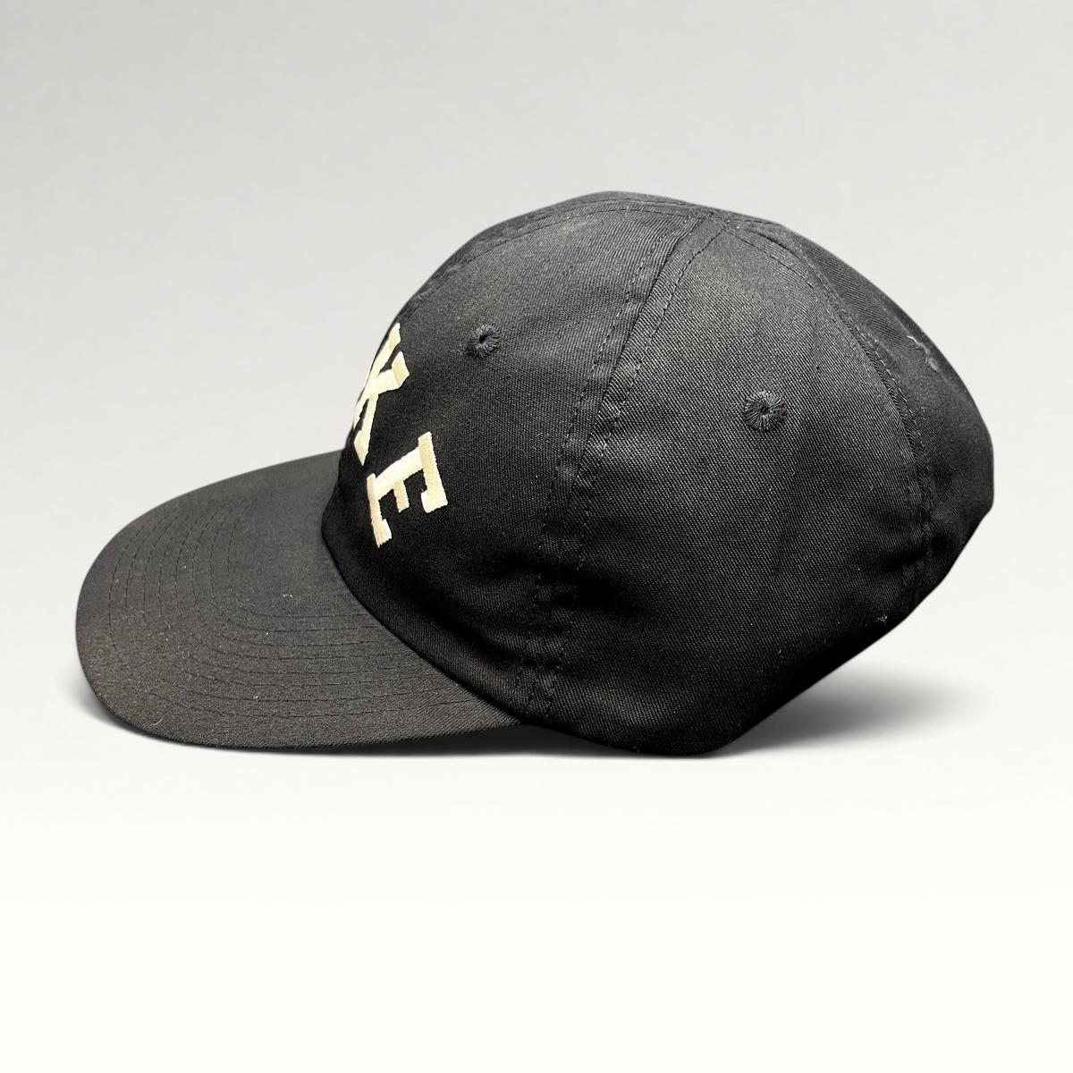 Raree Finds vintage black Nike strapback hat with embroidered arched logo and classic green undervisor
