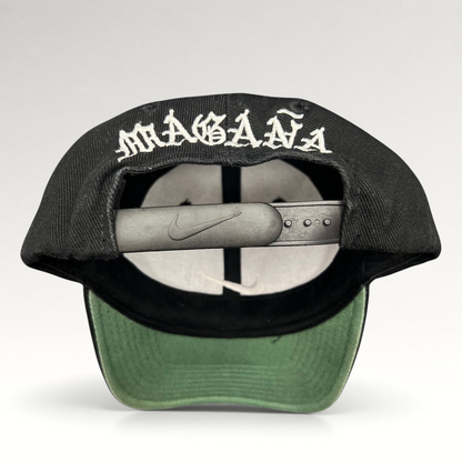 Raree Finds vintage 90s Nike snapback cap in black with Magaña script embroidered on the back and green undervisor.