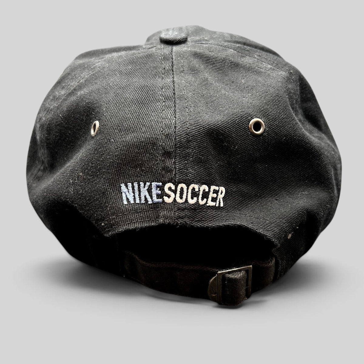 Raree Finds vintage black Nike Soccer strapback hat with embroidered logo and adjustable metal buckle back closure.