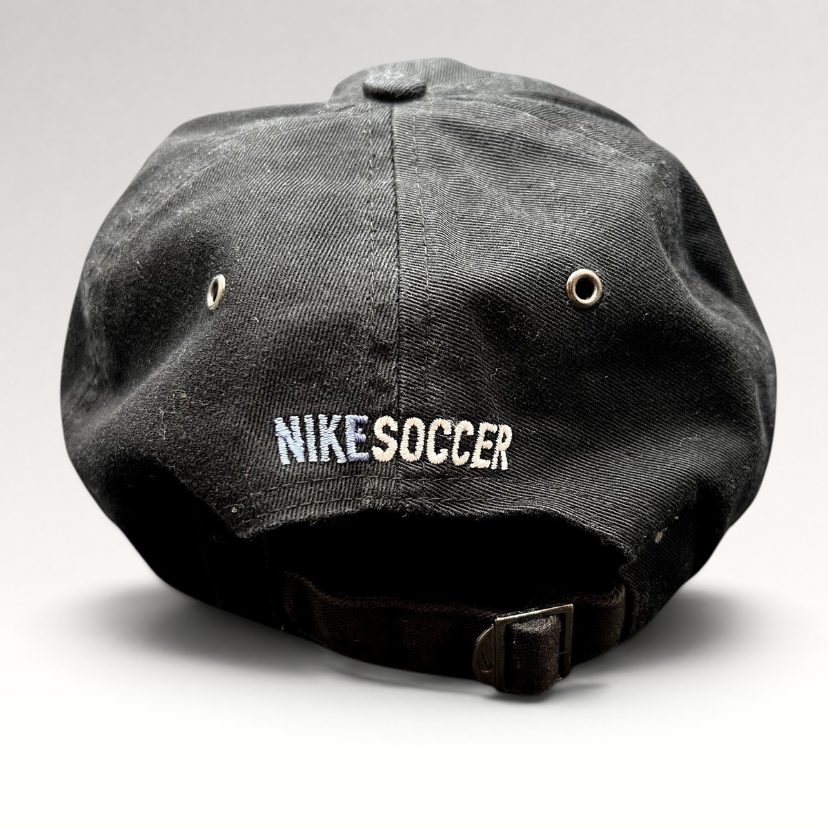 Raree Finds vintage black Nike Soccer strapback hat with embroidered logo and adjustable metal buckle back closure.