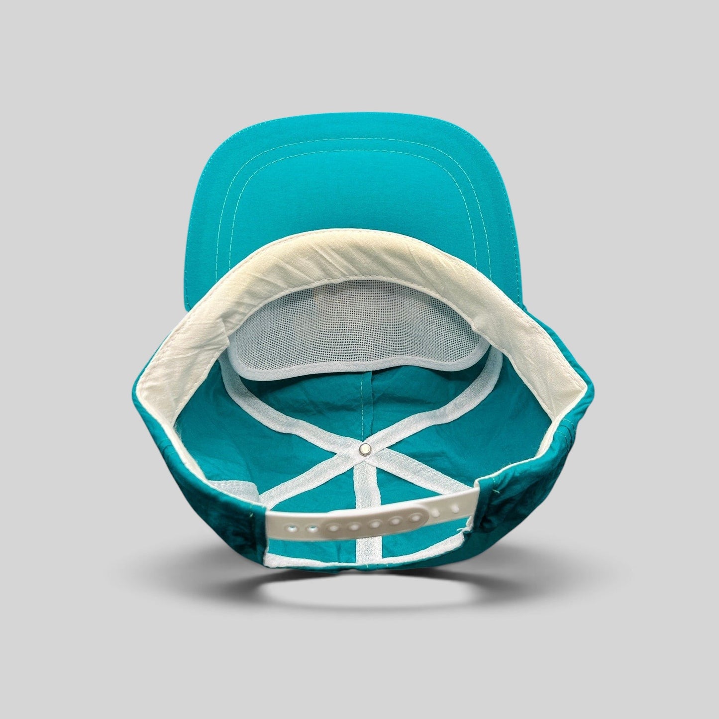 Raree Finds vintage 1992 Aspen Air Show snapback hat interior view showing teal nylon, white mesh, and snap closure.