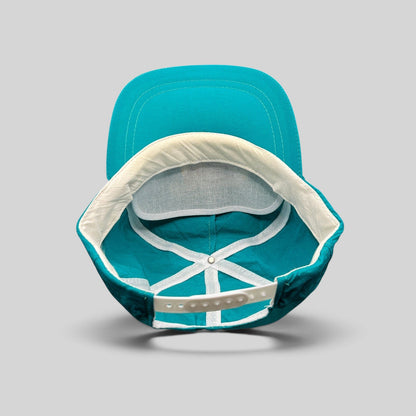 Raree Finds vintage 1992 Aspen Air Show snapback hat interior view showing teal nylon, white mesh, and snap closure.