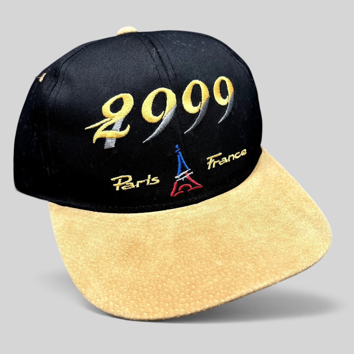 Raree Finds vintage Y2K Paris France snapback hat with black crown, tan suede brim, and 2000 Eiffel Tower embroidery.
