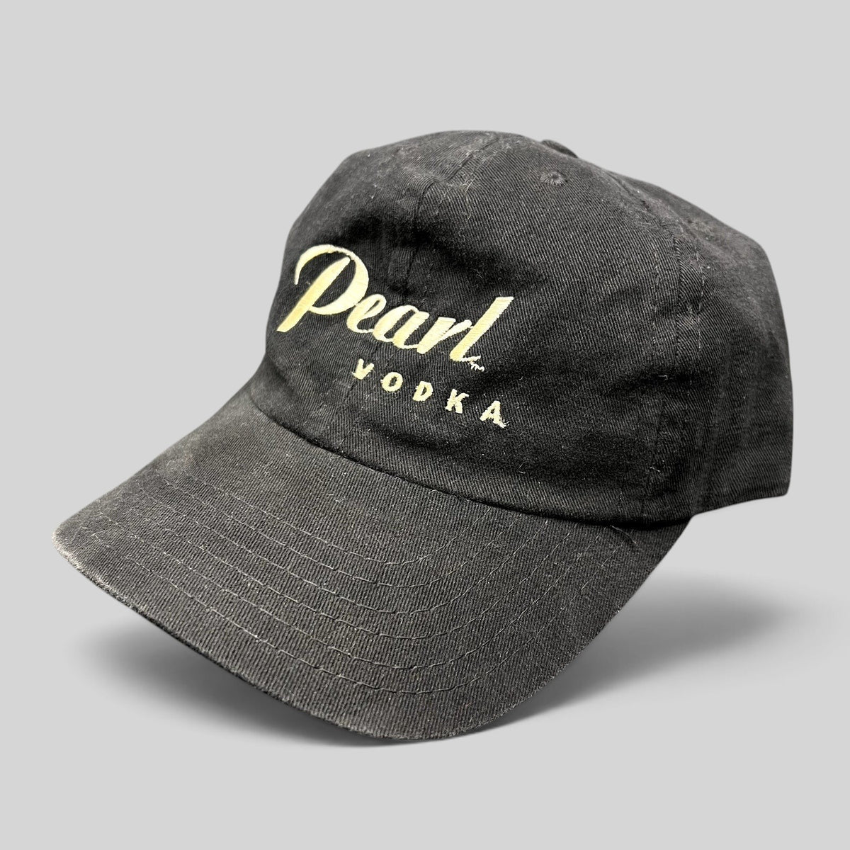 Raree Finds vintage black Pearl Vodka promotional snapback hat with cream embroidered logo and curved brim.
