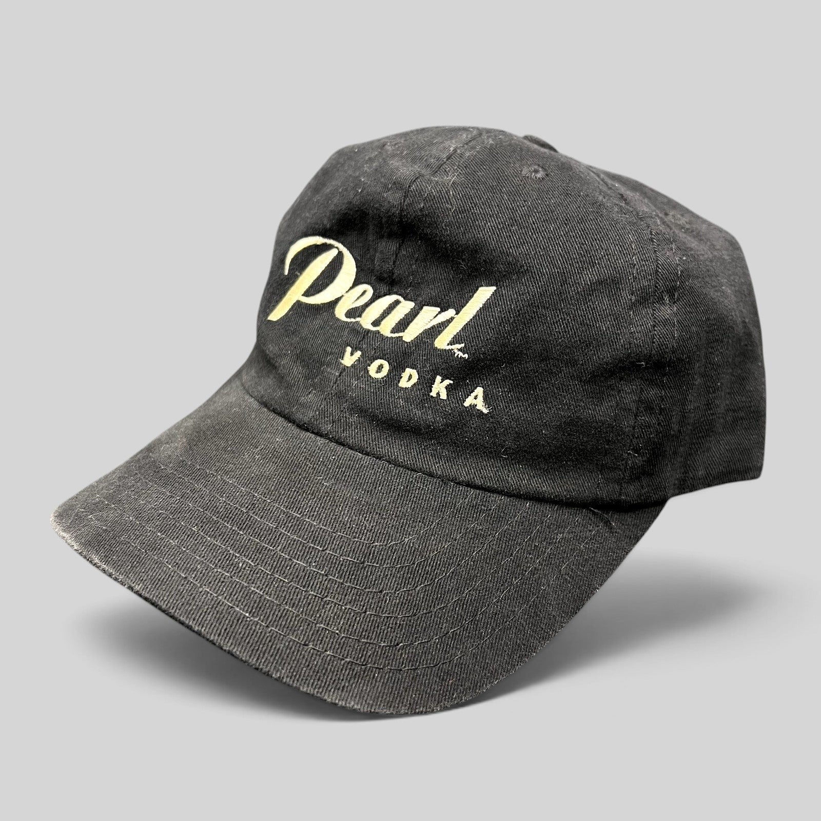 Raree Finds vintage black Pearl Vodka promotional snapback hat with cream embroidered logo and curved brim.