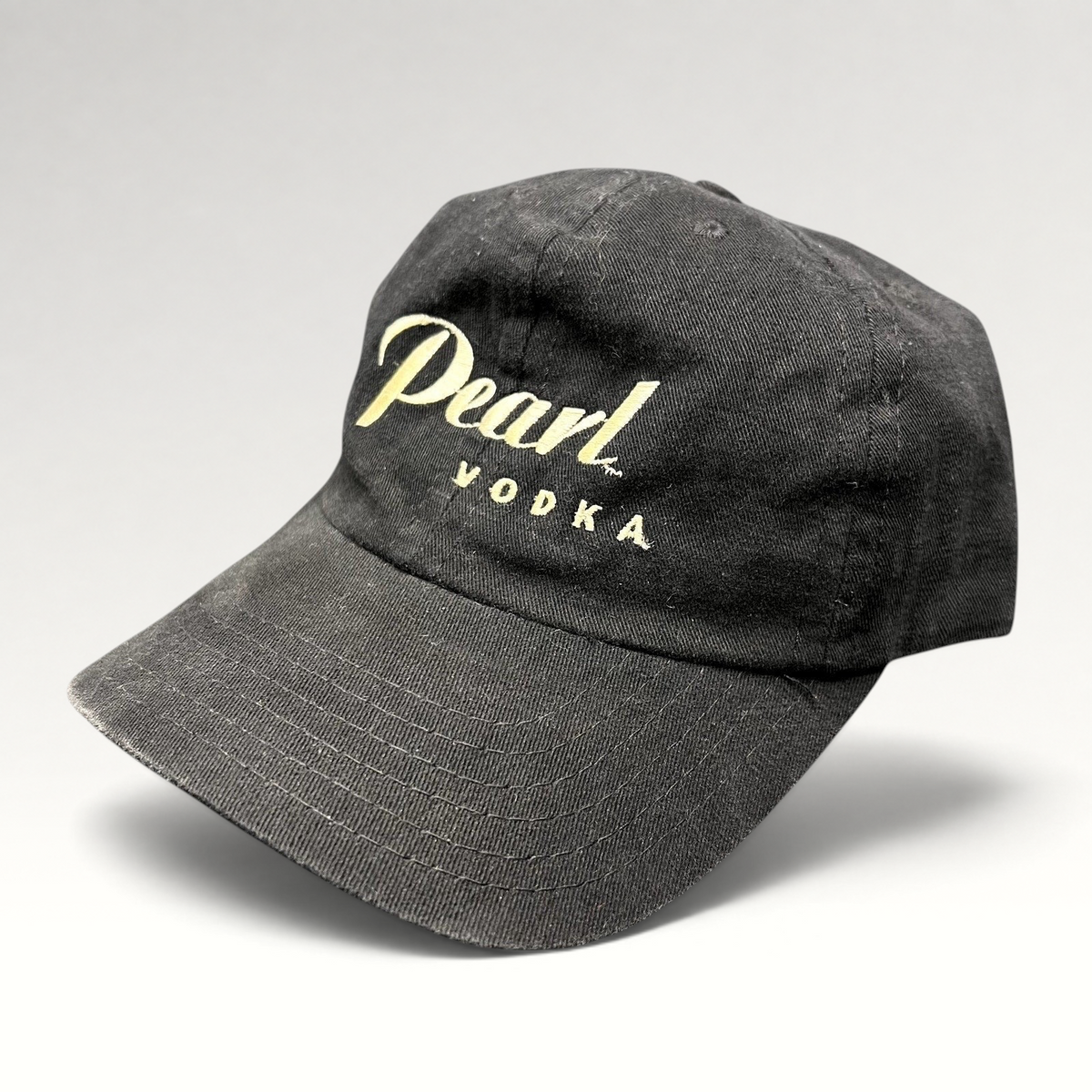 Raree Finds vintage black Pearl Vodka promotional snapback hat with cream embroidered logo and curved brim.