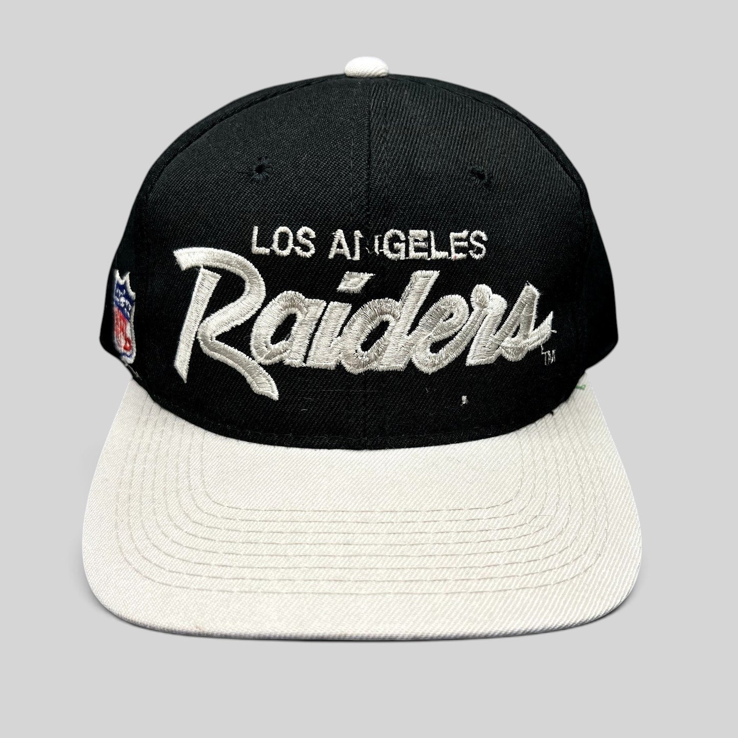 Raree Finds vintage Los Angeles Raiders Sports Specialties snapback hat with black crown, white brim, and script logo.