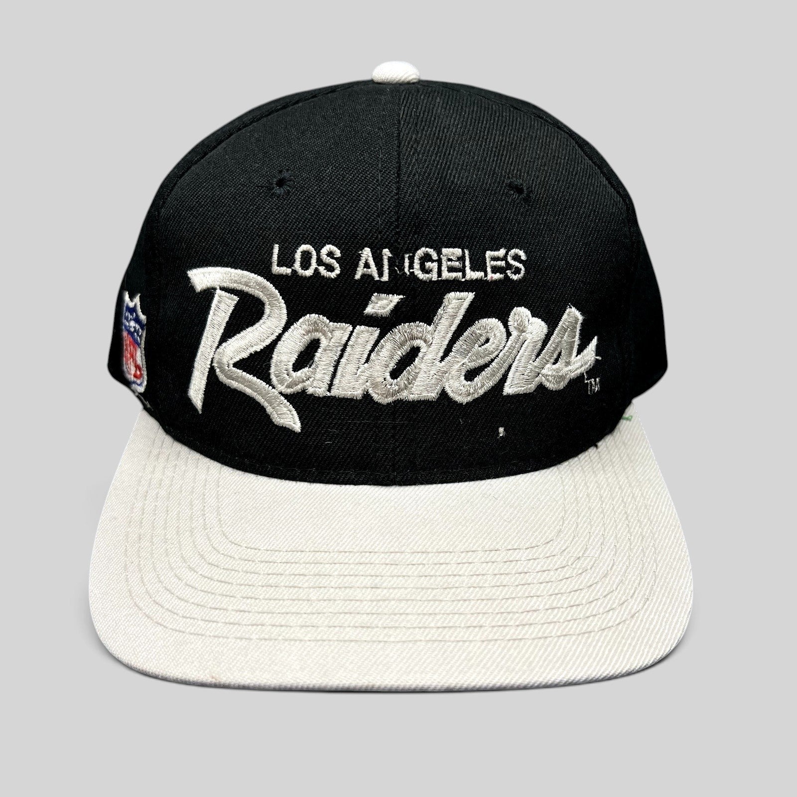 Raree Finds vintage Los Angeles Raiders Sports Specialties snapback hat with black crown, white brim, and script logo.
