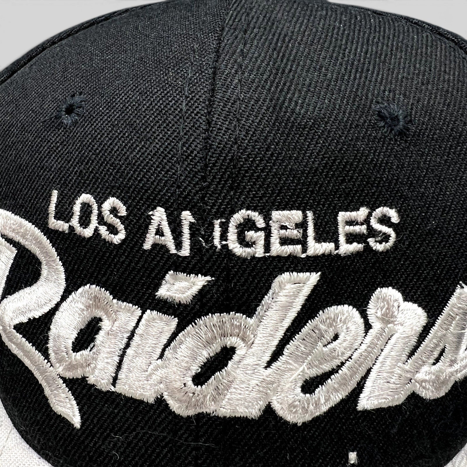 Raree Finds vintage Los Angeles Raiders snapback hat with white script embroidery on a black crown