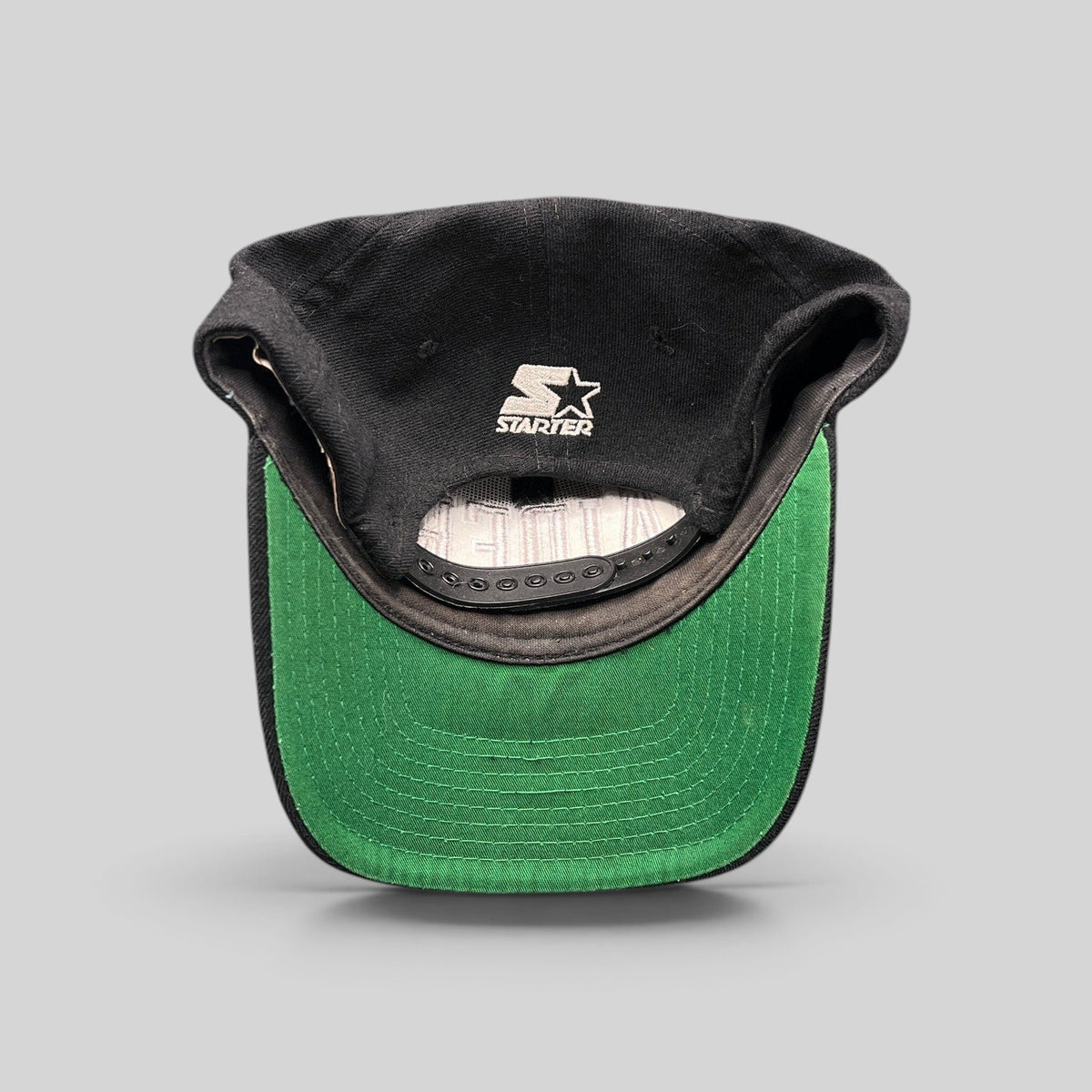 Raree Finds vintage 1990s Starter Raiders wool snapback interior showing the Starter logo and kelly-green underbrim