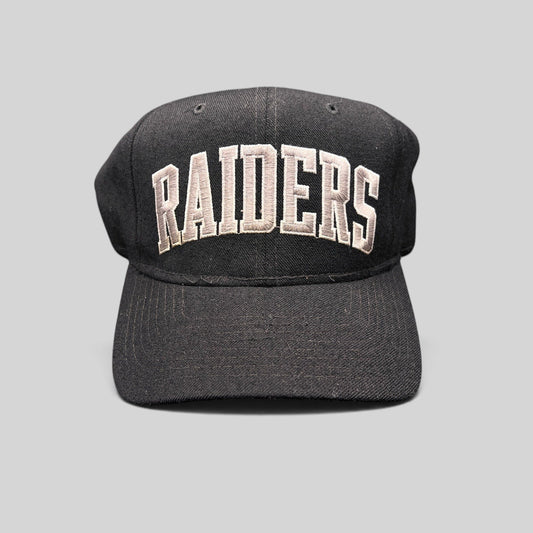 Raree Finds vintage 1990s Starter Los Angeles Raiders wool snapback hat in black with silver arch logo embroidery.