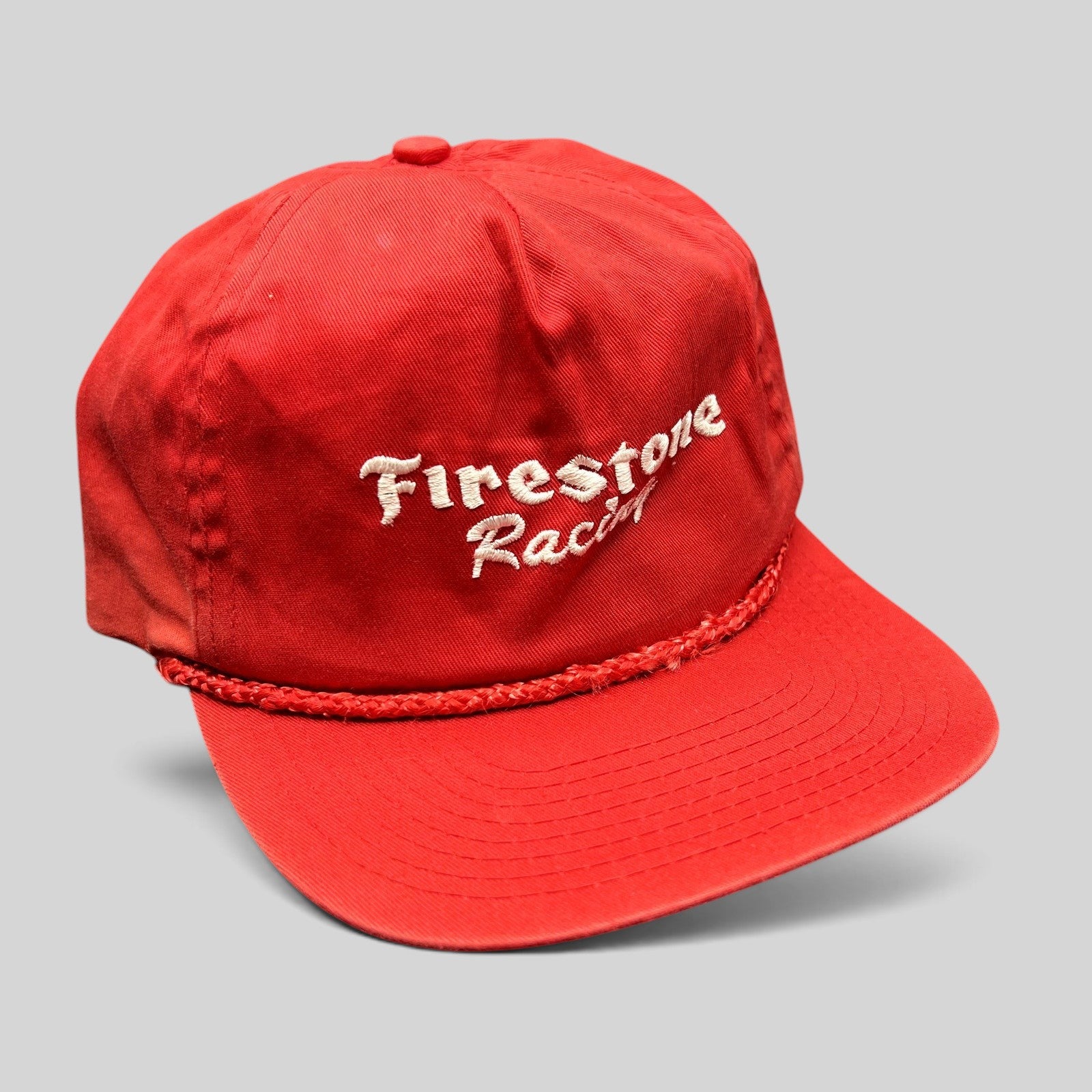Raree Finds vintage red Firestone Racing snapback hat with white embroidered logo and braided rope brim detail.