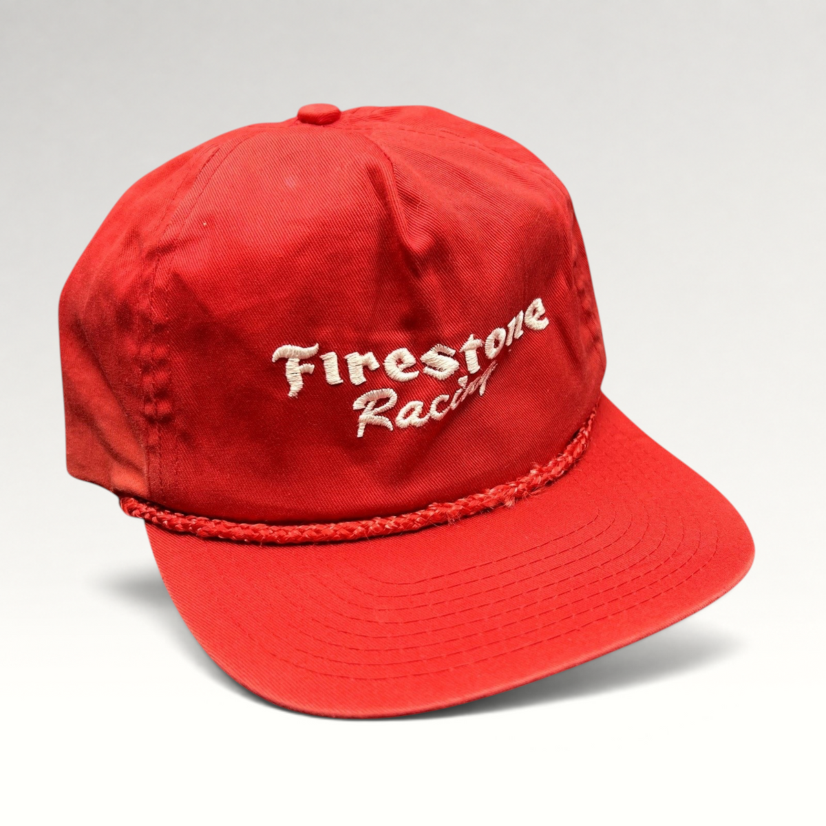 Raree Finds vintage red Firestone Racing snapback hat with white embroidered logo and braided rope brim detail.