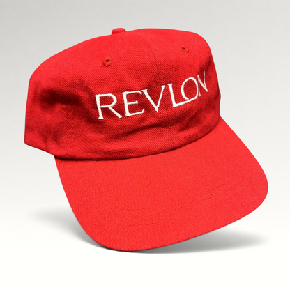 Raree Finds vintage bright red Revlon promotional strapback hat with white embroidered lettering on the front panel.