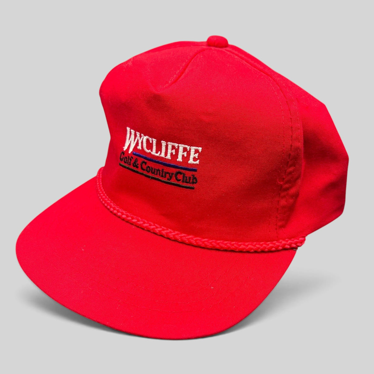 Raree Finds vintage red snapback hat with white Wycliffe Golf & Country Club embroidery and decorative rope trim.