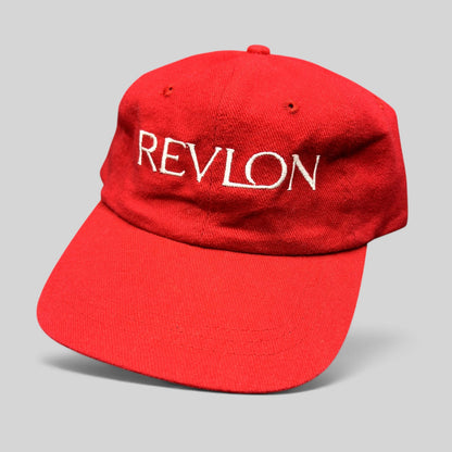 Raree Finds vintage red Revlon promotional strapback hat with white embroidered lettering on the front panel.