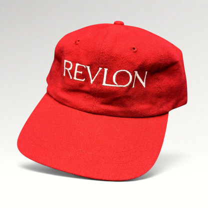 Raree Finds vintage red Revlon promotional strapback hat with white embroidered lettering on the front panel.