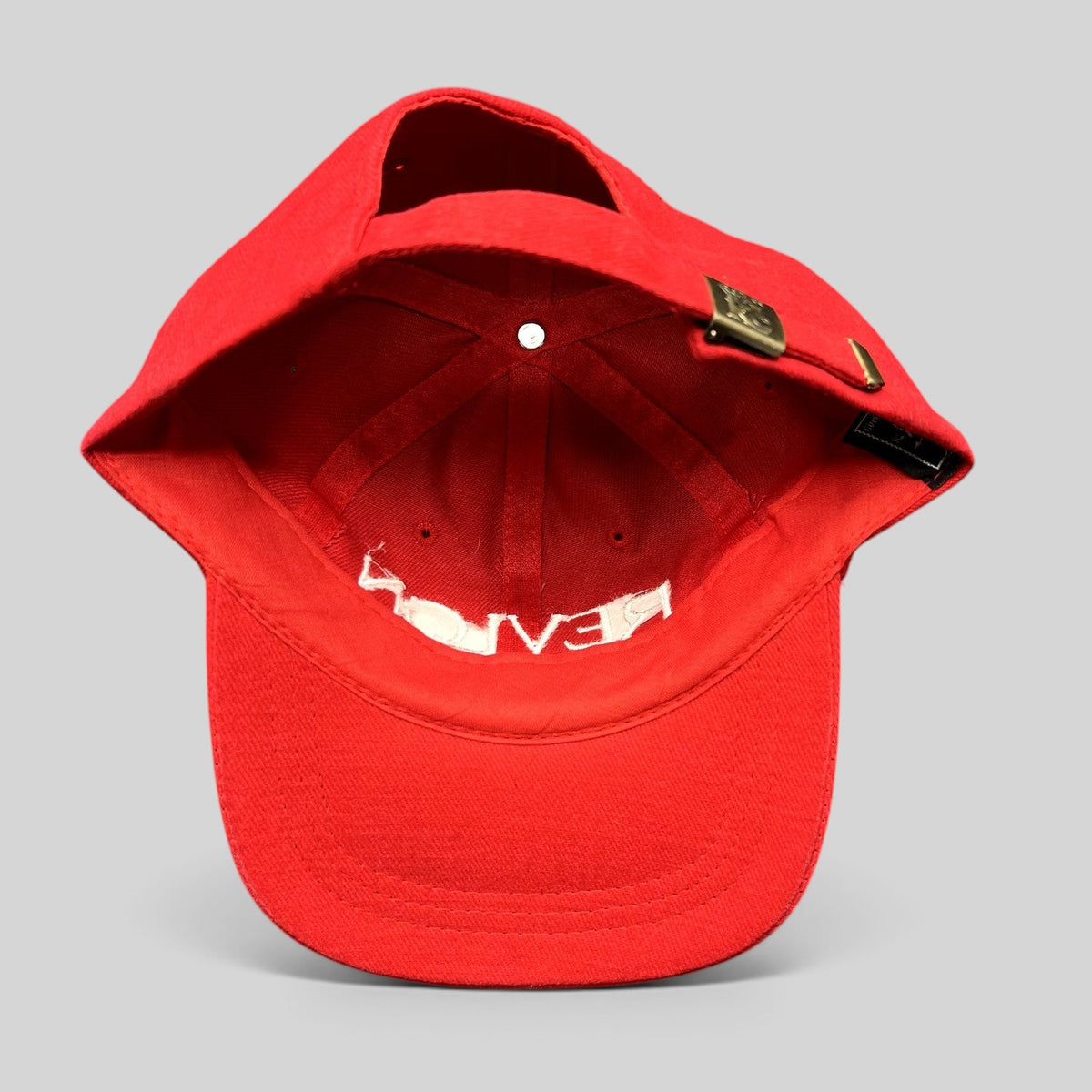 Raree Finds vintage red Revlon promotional strapback hat with adjustable metal buckle closure and interior branding.