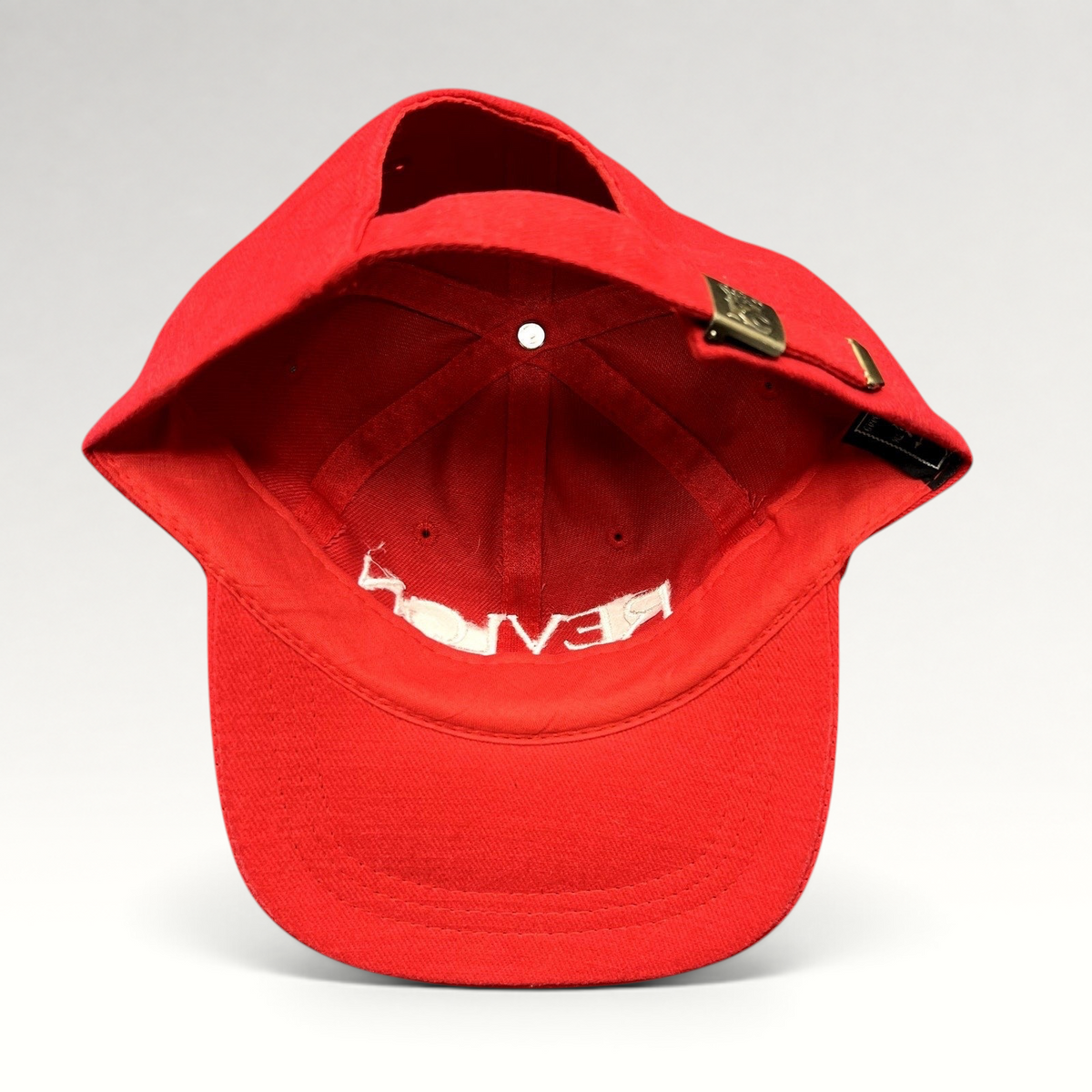 Raree Finds vintage red Revlon promotional strapback hat with adjustable metal buckle closure, interior view.