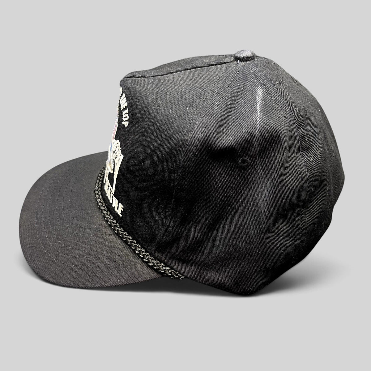 Raree Finds vintage 90s black snapback hat with Seattle Space Needle embroidery and braided rope detail on the brim.