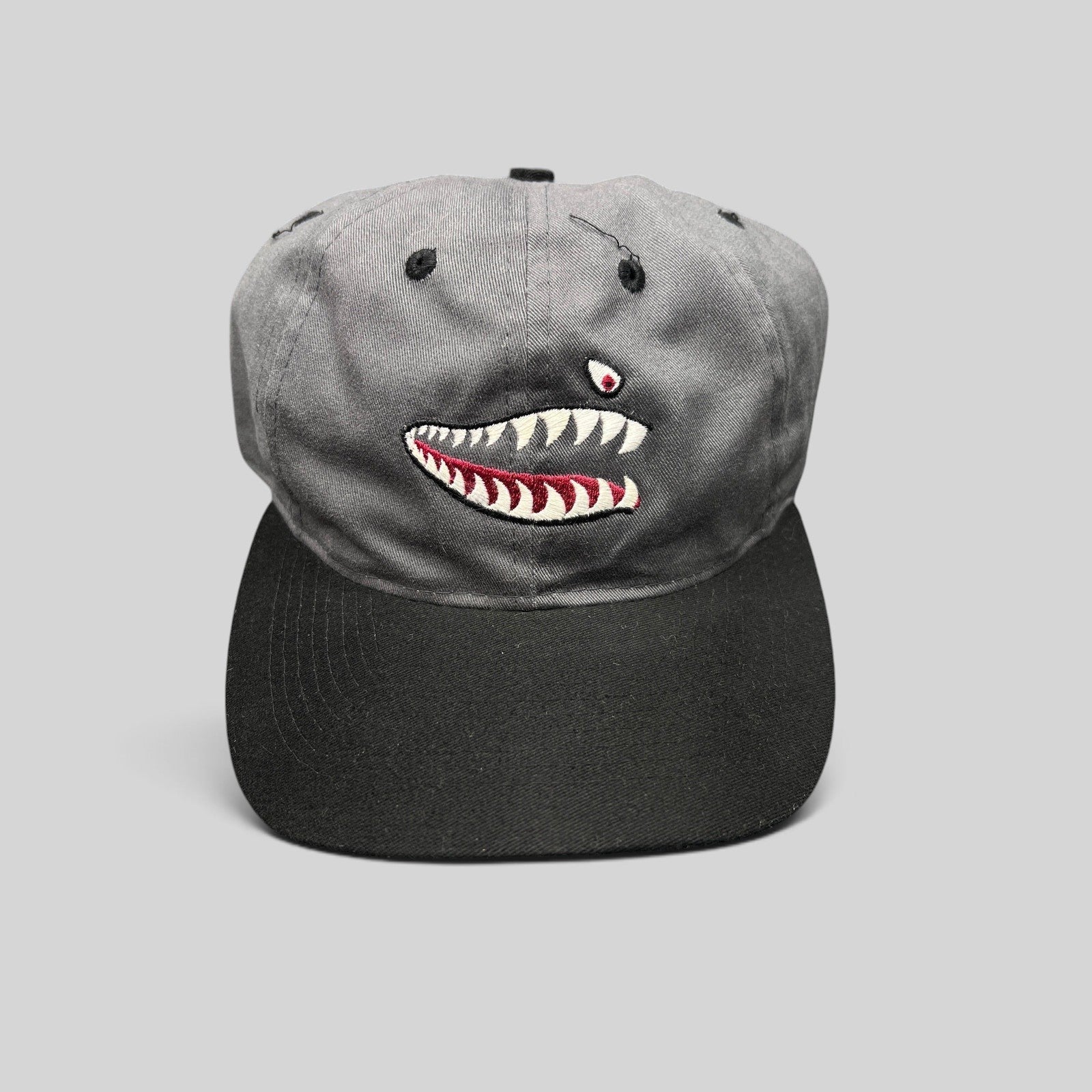 Raree Finds vintage Otto Cap snapback featuring embroidered P-40 Warhawk shark mouth art on a gray and black cotton hat.