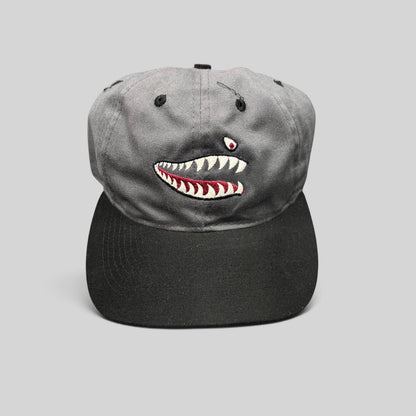Raree Finds vintage Otto Cap snapback featuring embroidered P-40 Warhawk shark mouth art on a gray and black cotton hat.