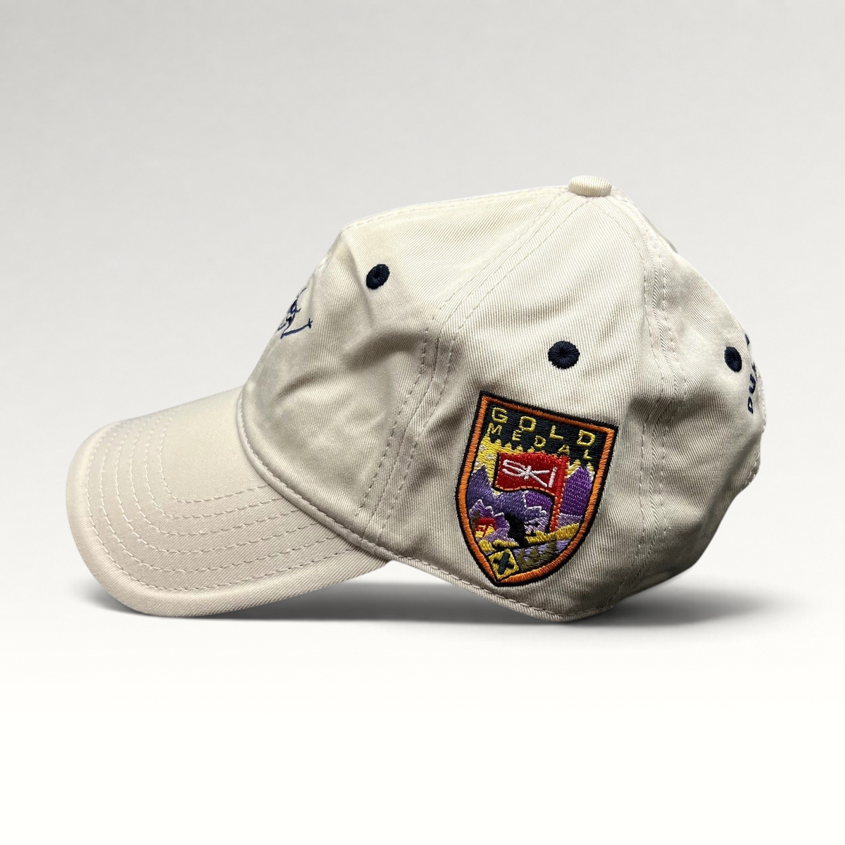 Raree Finds vintage cream cotton strapback hat with embroidered Gold Medal ski patch and navy blue accents