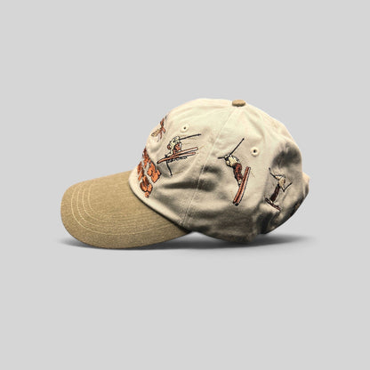 Raree Finds vintage 90s Attitude strapback hat with stone crown, olive brim, and wrap-around embroidered ski graphics.