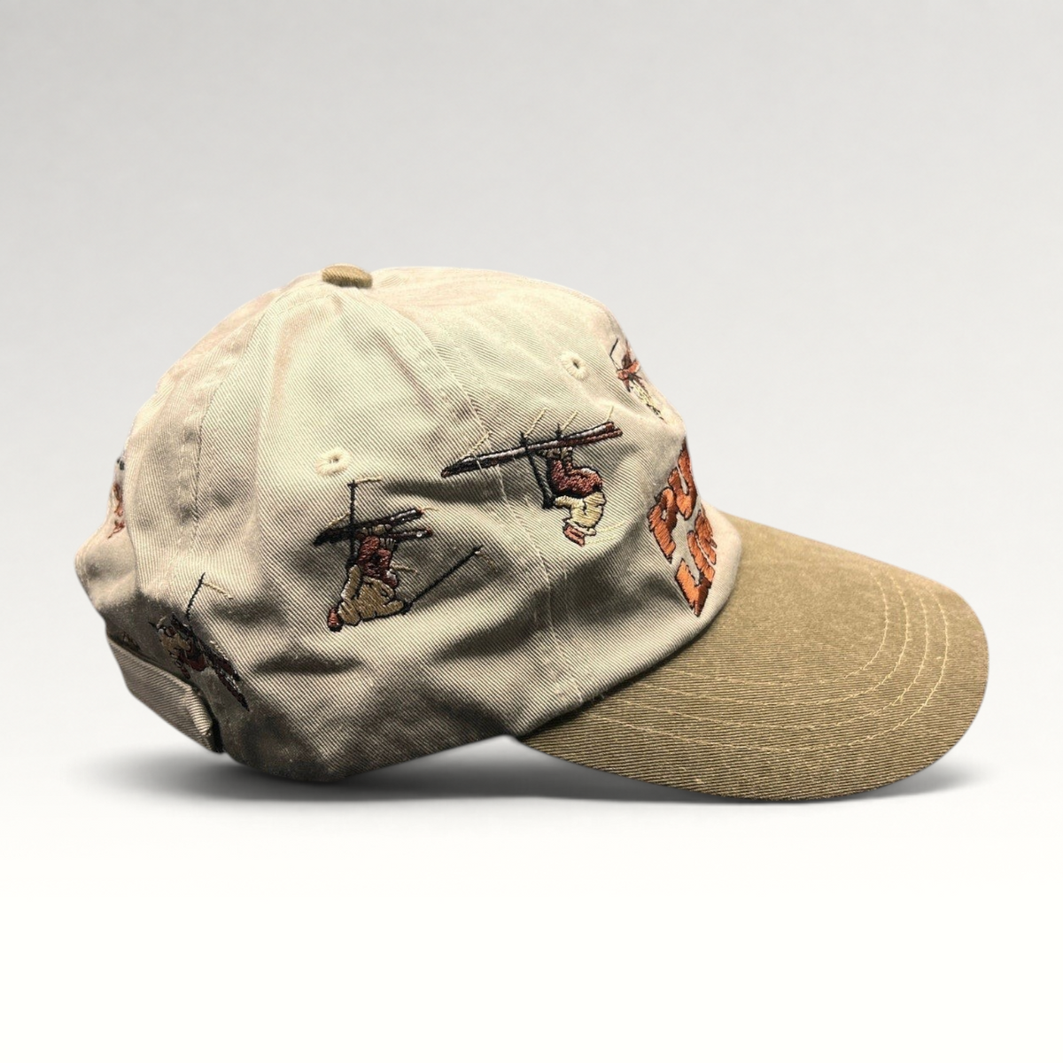 Raree Finds vintage 90s Attitude brand strapback hat in stone and olive with wrap-around embroidered skier graphics.