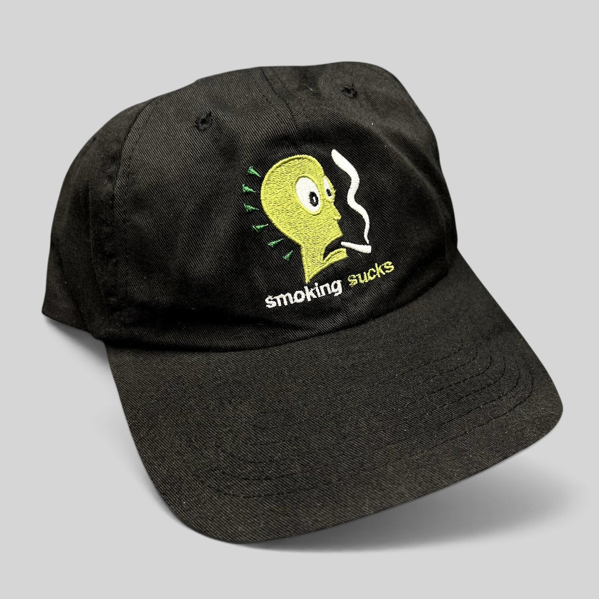 Raree Finds vintage black snapback hat featuring a green embroidered cartoon character and Smoking Sucks text.
