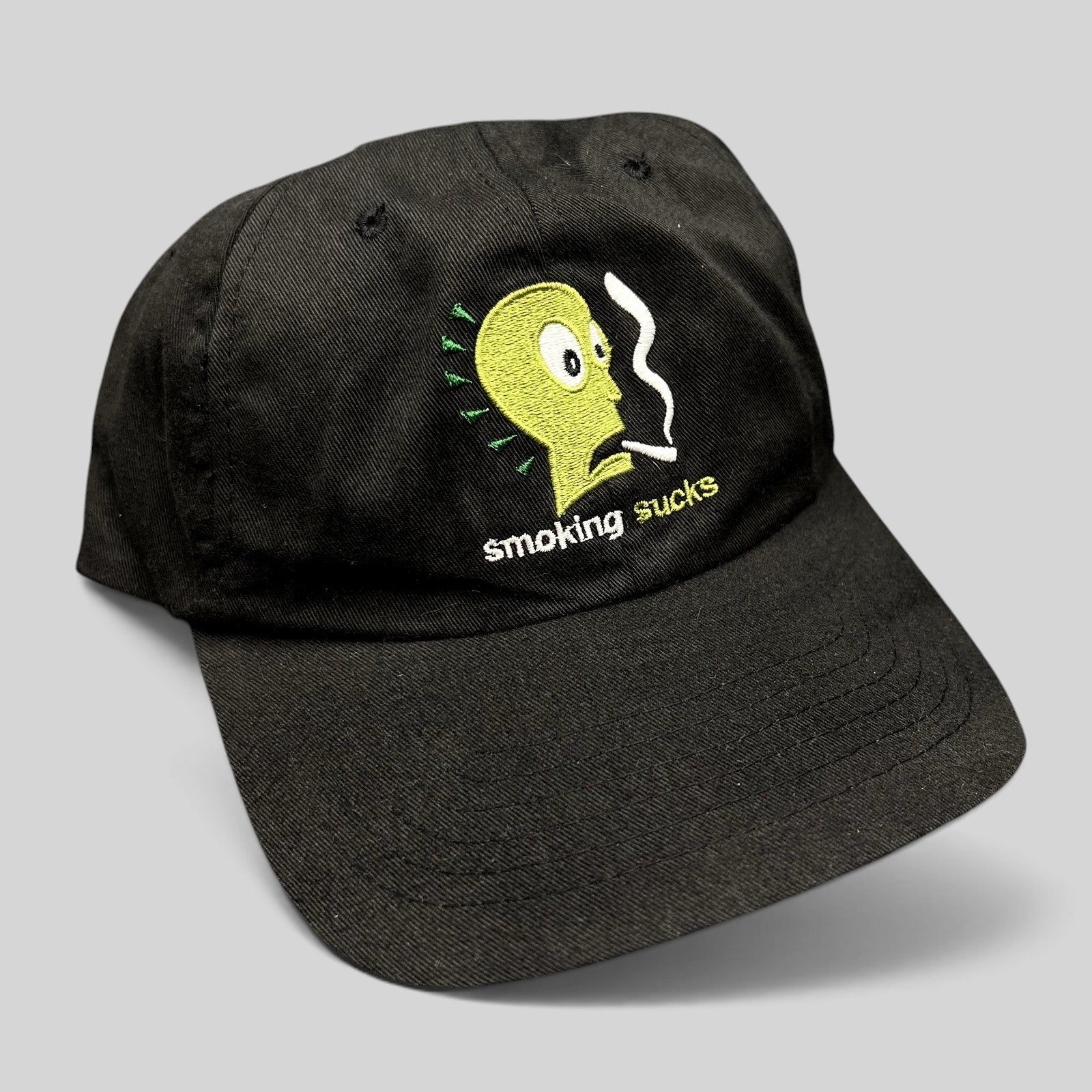 Raree Finds vintage black snapback hat featuring a green embroidered cartoon character and Smoking Sucks text.