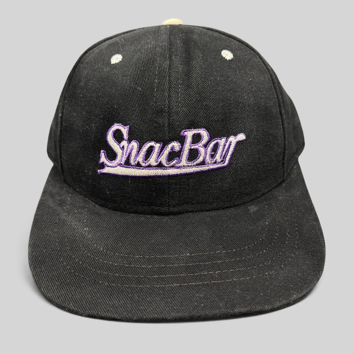 Raree Finds vintage 90s black snapback hat with purple SnacBar script embroidery and a structured front panel