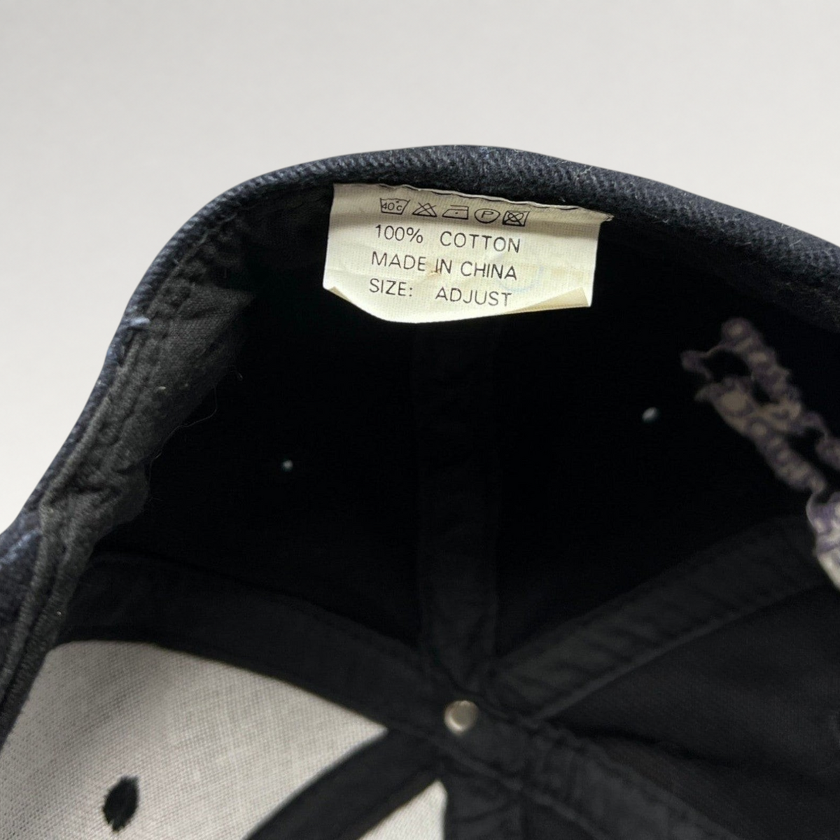 Raree Finds vintage Jimmy V snapback hat interior tag showing 100 percent cotton material and adjustable sizing