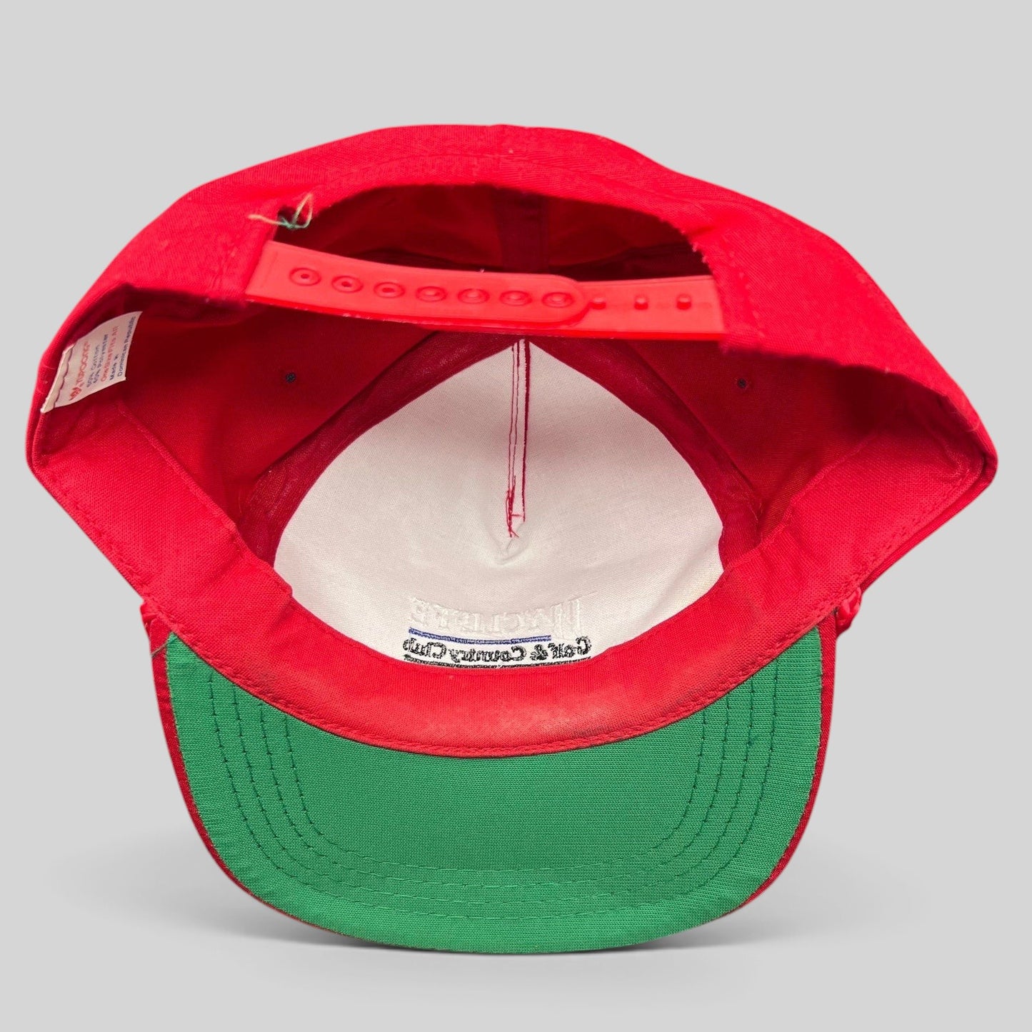 Raree Finds vintage snapback hat interior view showing red crown, green brim, and adjustable plastic strap
