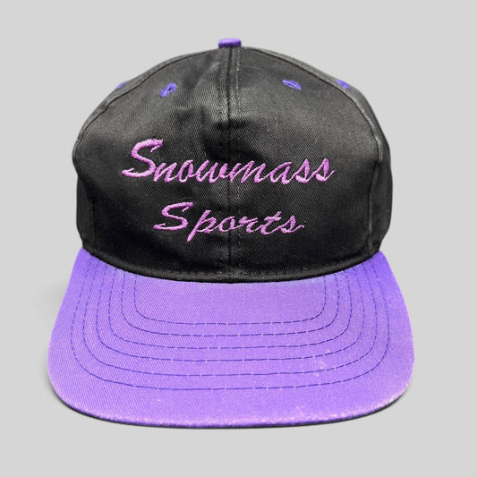 Raree Finds vintage 90s Snowmass Sports strapback hat with a black crown and vibrant purple brim and embroidery.
