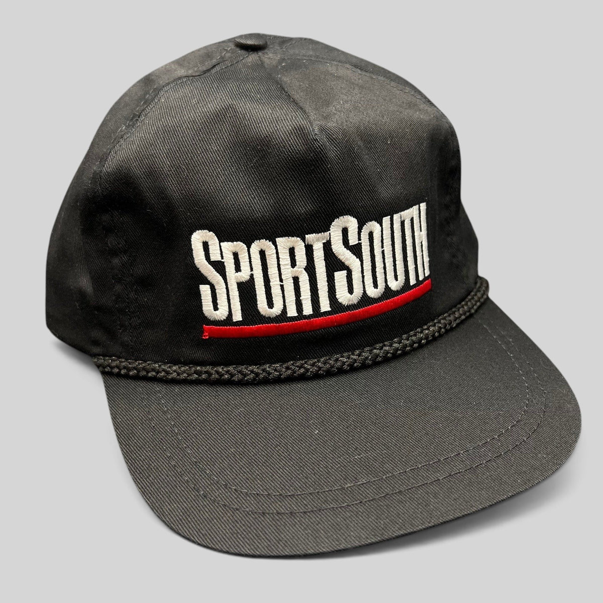 Raree Finds vintage black SportSouth rope strapback hat with white and red embroidery and a classic green underbrim.