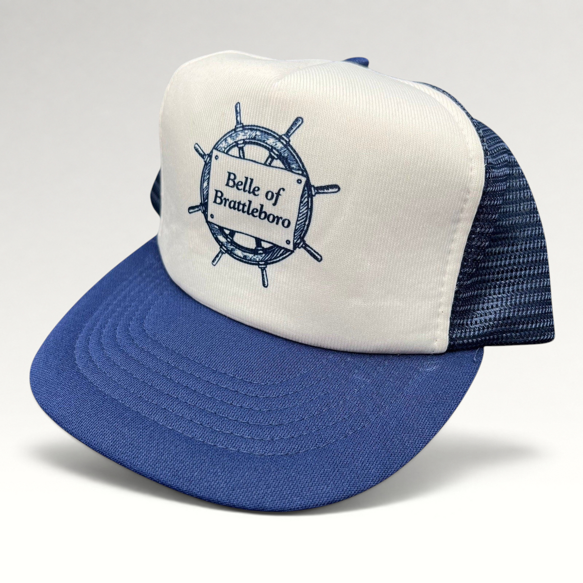Raree Finds vintage Sunbelt trucker hat with white foam front, navy mesh back, and Belle of Brattleboro ship graphic.