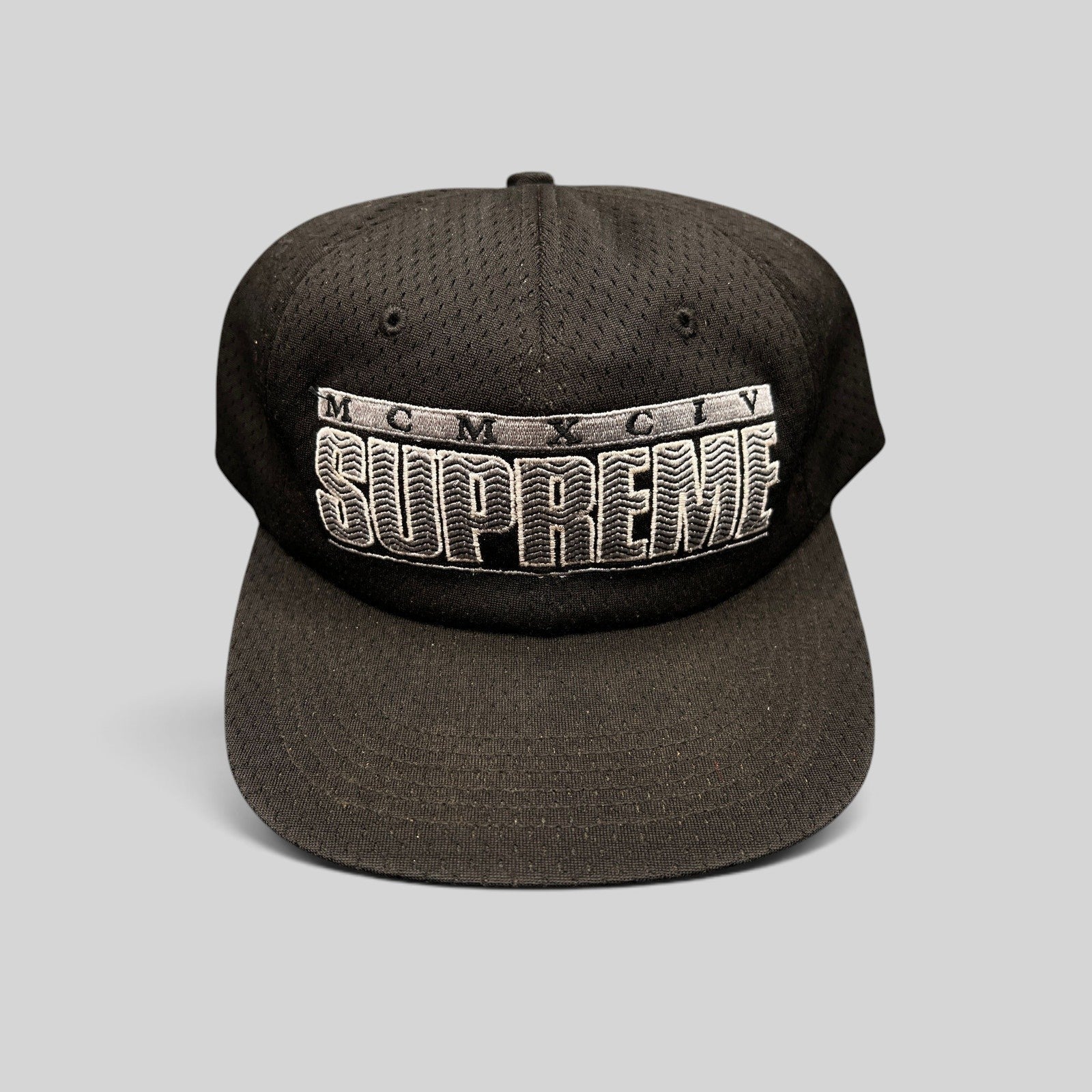 Raree Finds vintage black Supreme mesh snapback hat featuring raised 3D MCMXCIV embroidery and adjustable closure.