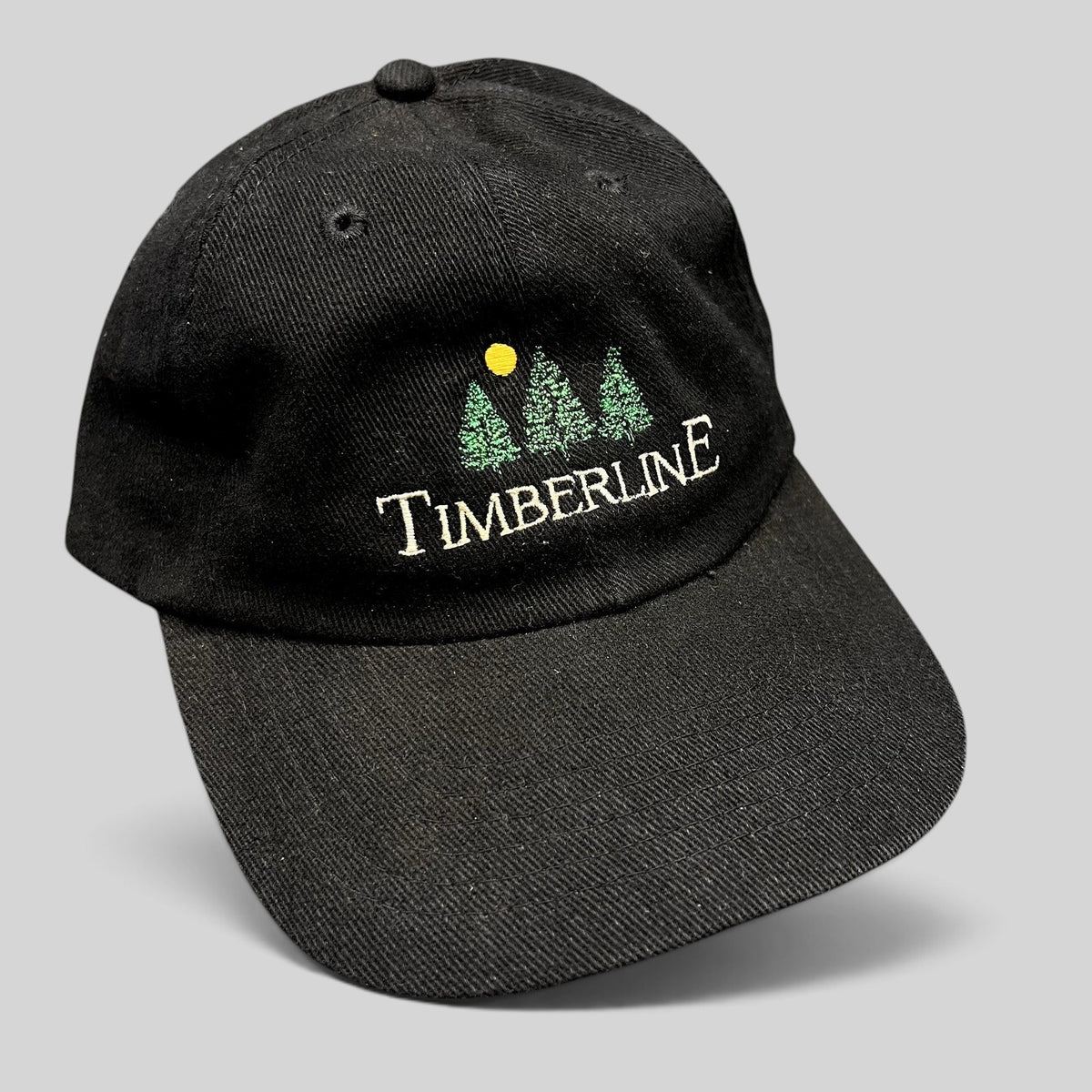 Raree Finds vintage 1990s black Timberline strapback dad hat with embroidered green pine trees and yellow sun logo