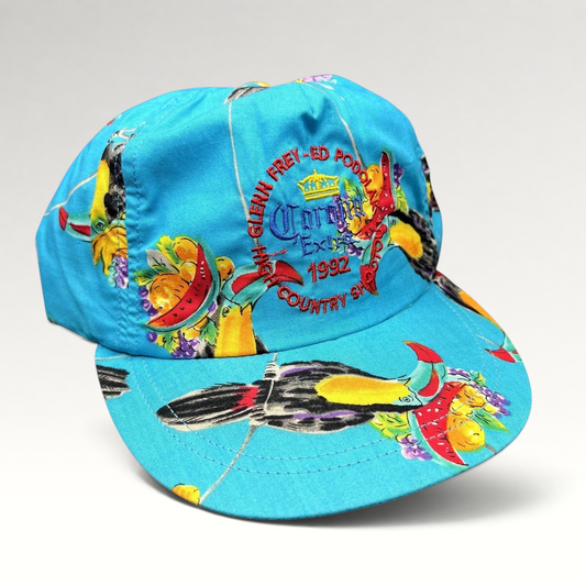 Raree Finds vintage 1992 High Country Shootout golf hat in turquoise with tropical toucan print and strapback closure.