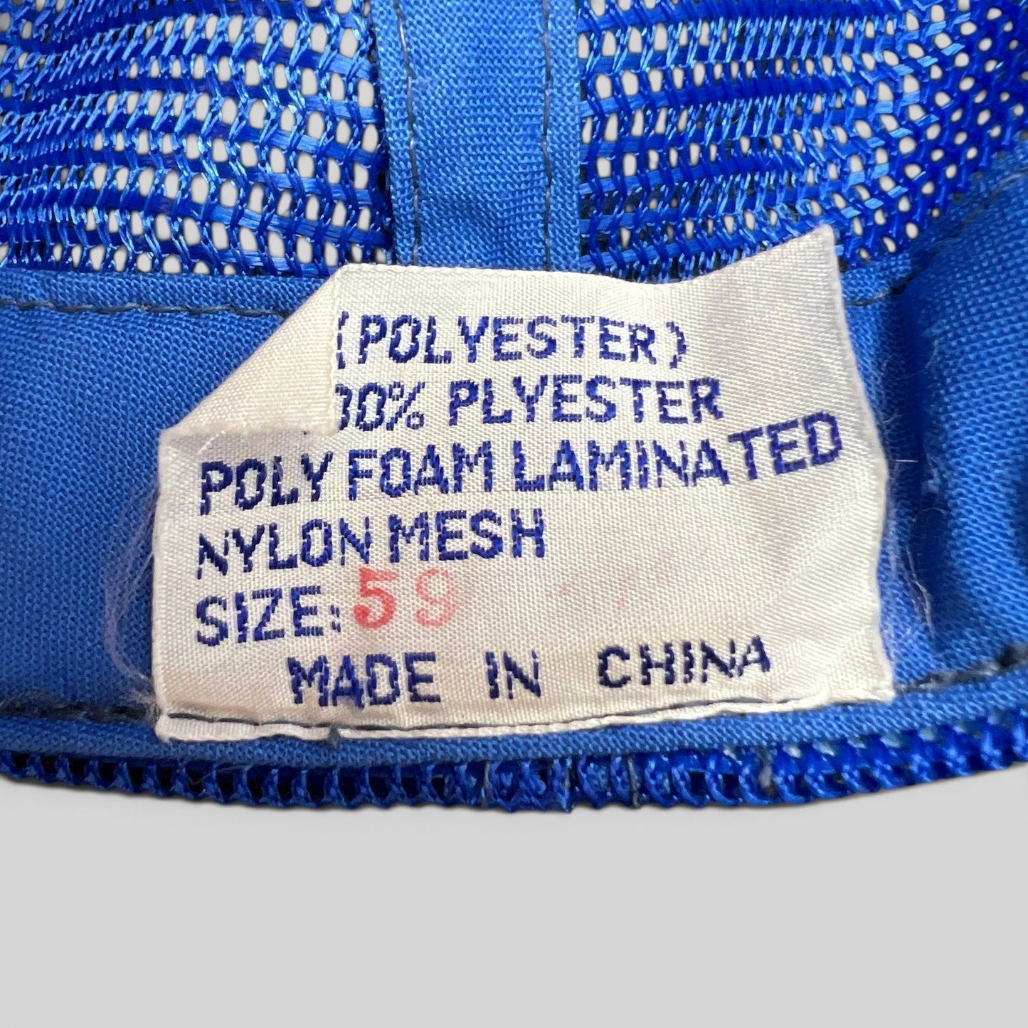 Raree Finds vintage trucker hat interior care label showing polyester and nylon mesh material composition