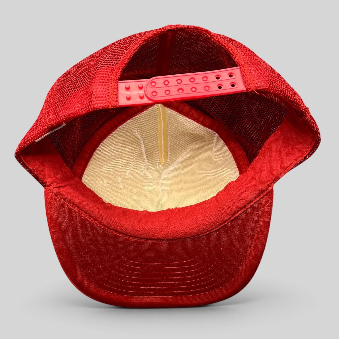 Raree Finds vintage 1996 trucker hat interior showing red mesh back, white foam front, and adjustable snapback closure.