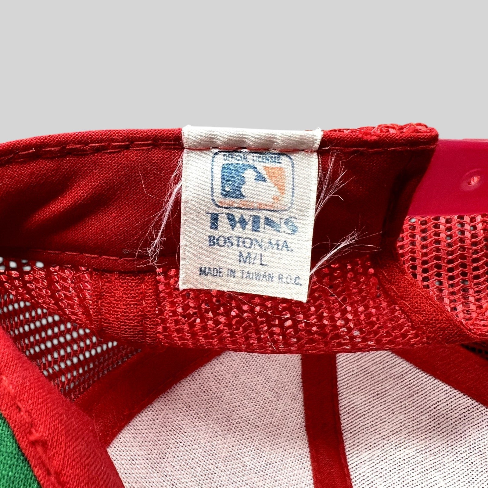 Raree Finds vintage Twins Enterprise MLB hat label showing official licensing and Made in Taiwan origin on red mesh