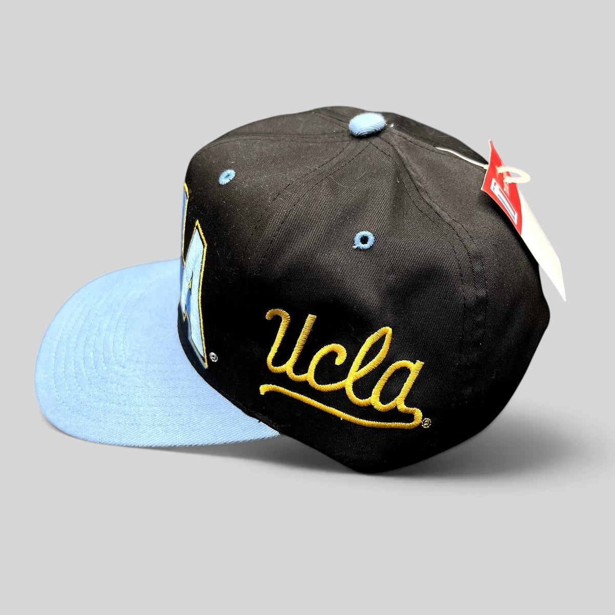 Raree Finds vintage UCLA Bruins snapback hat in black and powder blue with side script embroidery and adjustable strap.