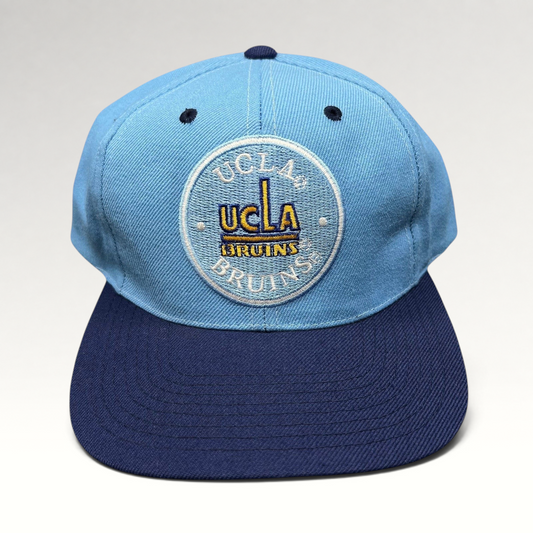 Raree Finds vintage AJD UCLA Bruins snapback hat with light blue crown, navy brim, and circular embroidered logo.