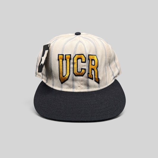 Raree Finds vintage 90s UCR pinstripe snapback hat with gold and navy embroidery and a navy flat brim.