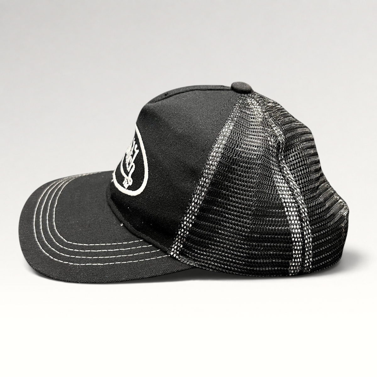 Raree Finds vintage Von Dutch black and white trucker hat with embroidered logo, mesh back, and contrast stitching.