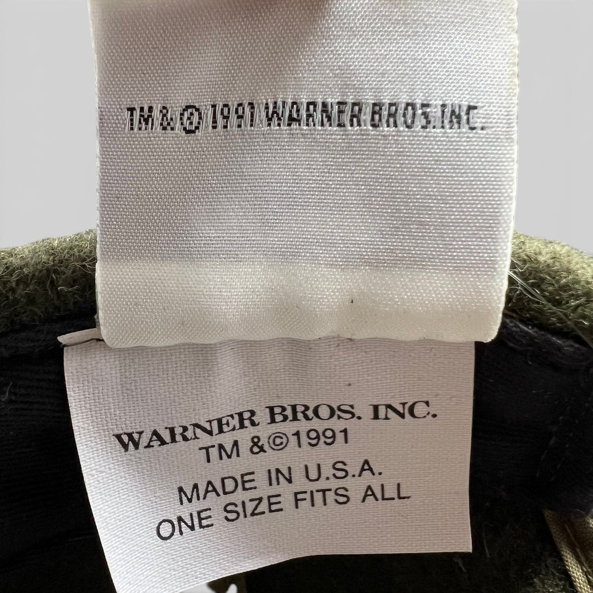 Raree Finds vintage 1991 Warner Bros. interior tag on a Harley-Davidson Taz hat, showing Made in U.S.A. details.